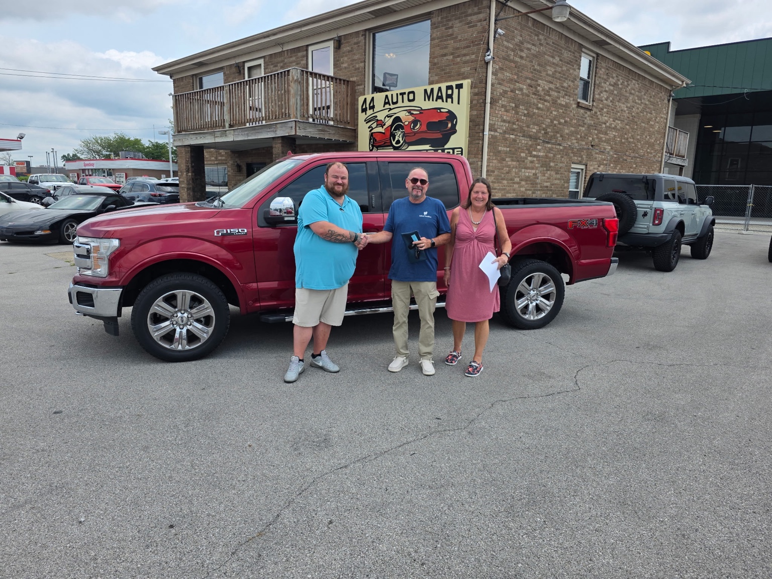 Darrell with customers and a red Ford F-150