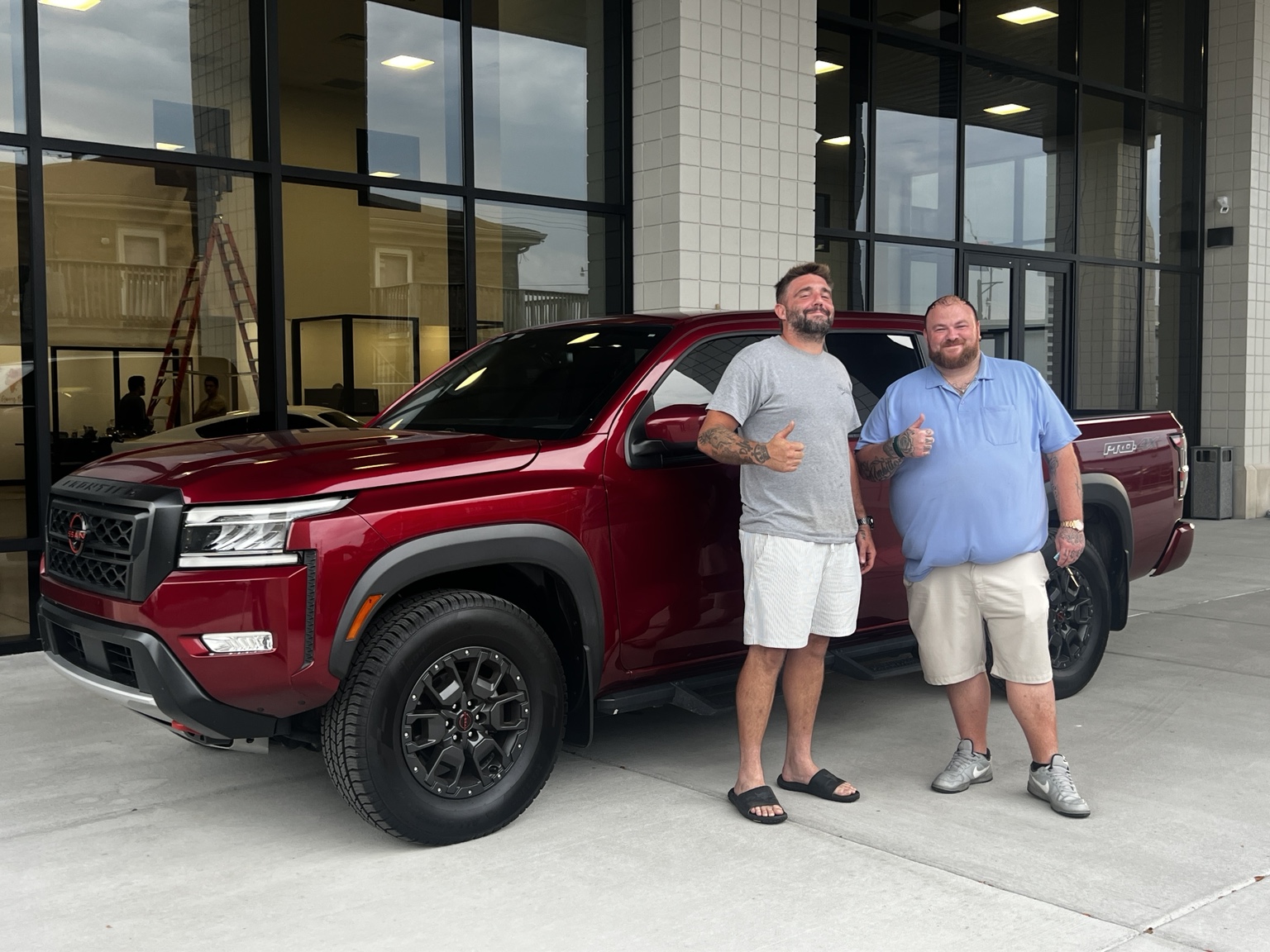 Darrell with a customer and a red Nissan Frontier